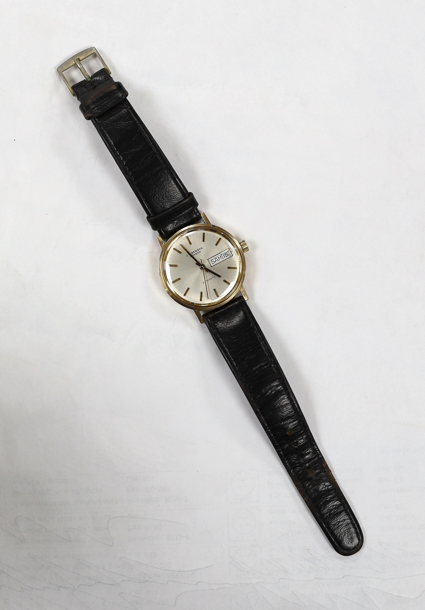 A gentleman's yellow metal (Swiss 9ct mark) J.W. Benson automatic day(in French & English)/date wrist watch, on associated strap, case diameter 34mm, gross weight 36.8 grams.